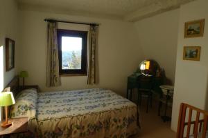 una camera da letto con un letto, una finestra e un tavolo di Casa da Serra a Penhas da Saúde Altre 6 foto