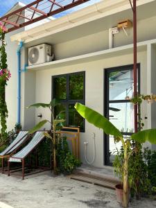 a house with a bench in front of it at Naares Inn Dhigurah in Dhigurah +8 photos