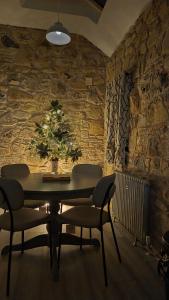 Cobbles cottage - 2 bedroom stone built cottage في Ballynahinch: غرفة طعام مع طاولة وكراسي وشجرة عيد الميلاد