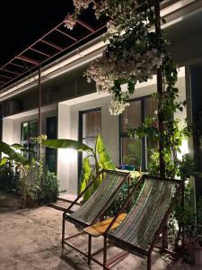 two chairs sitting on a patio in front of a building at Naares Inn Dhigurah in Dhigurah