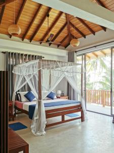 a bedroom with a bed with a canopy at Galawatta Beach Resort in Unawatuna