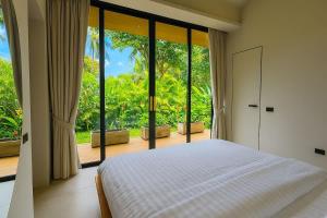 a bedroom with a bed and a large window at AVA Aurora Villa in Wok Tum