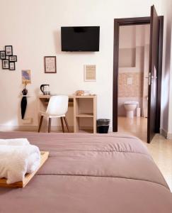 ein Schlafzimmer mit Bett, Schreibtisch und Fernseher in der Unterkunft Rooms hub Portarotese in Salerno