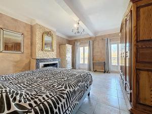 a bedroom with a black and white bed and a fireplace at Le Mirabeau - Appartement bourgeois - Terrasse 80m2 - Wifi et Climatisation in Narbonne