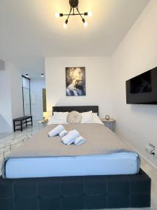 a bedroom with a large bed with two towels on it at Apartament Natura in Piła