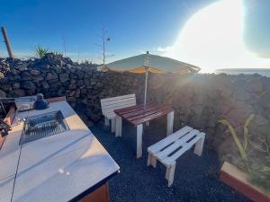 阿里亚The Secret Garden Lanzarote的一张带雨伞和两个长椅的野餐桌