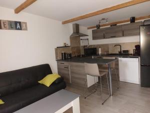 Appartement cosy au cœur de la Provence في جرافيزون: غرفة معيشة مع أريكة ومطبخ
