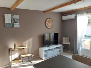 Appartement cosy au cœur de la Provence في جرافيزون: غرفة معيشة مع تلفزيون وخزانة بيضاء