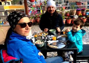 Eine Frau und ein Mann sitzen an einem Tisch mit einem Kind in der Unterkunft ColdFeet Home in Kathmandu + 6 Fotos
