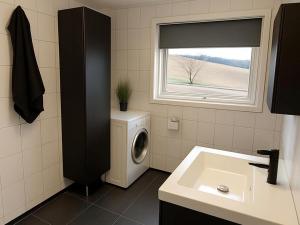 EtnesjøenにあるEtne Hytterのバスルーム(洗濯機付)、窓が備わります。