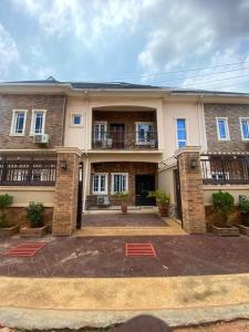 Un gran edificio de ladrillo con un patio delante. en Beautiful 2 beds with self compound and private parking space, en Iju Junction
