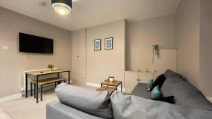 ein Wohnzimmer mit Sofa und Tisch in der Unterkunft Cosy 2-Bed Apartment - Nether Edge, Sheffield in Nether Edge