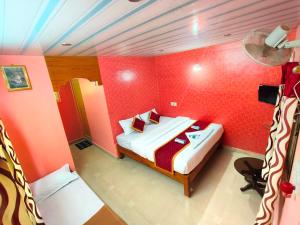 库斯哈尔纳加尔Rising Surya Homestay的一间红色客房内的卧室 更多36张照片