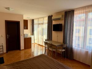 una stanza con tavolo e sedie e una camera da letto di Studio Helios a Sveti Vlas