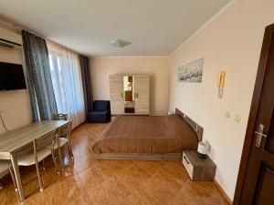 una camera da letto con un letto, un tavolo e una scrivania di Studio Helios a Sveti Vlas