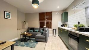 eine Küche und ein Wohnzimmer mit Sofa und Tisch in der Unterkunft Cosy 2-Bed Apartment - Nether Edge, Sheffield in Nether Edge + 9 Fotos