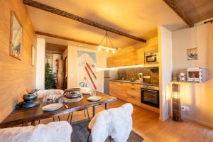 une cuisine avec une table et des chaises dans une pièce dans l'établissement Le Chalet Savoyard, à Hennebont