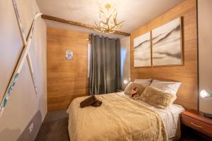 une chambre avec un lit et un lustre dans l'établissement Le Chalet Savoyard, à Hennebont