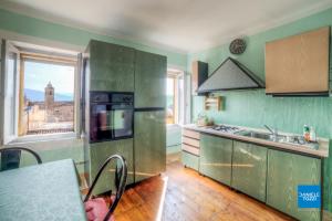 a kitchen with green cabinets and a view of a city at La Neviera Nel Pozzo in Offida