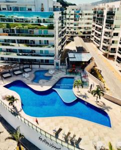 una grande piscina accanto a un grande condominio di Le Bon vivant Arraial do cabo 405 bl a ad Arraial do Cabo