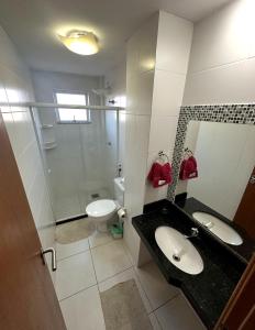 un bagno con due lavandini, una doccia e un WC di Le Bon vivant Arraial do cabo 405 bl a ad Arraial do Cabo