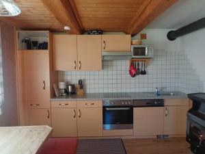 a kitchen with wooden cabinets and a stove at Ferienhütte Georg in Hippach