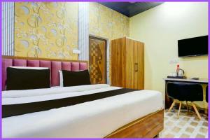a bedroom with a large bed and a desk at Hotel Rangoli Residency Near Sea Beach in Baga