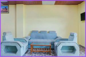 a living room with a blue couch and a table at Hotel Rangoli Residency Near Sea Beach in Baga
