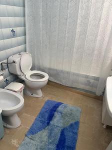 a bathroom with a toilet and a blue rug at Reposo in Nikolítsion