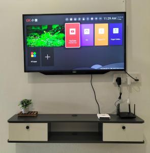 Un televisor de pantalla plana colgado en una pared en Room&Rest Homestay Seremban Mutiara Galla, en Seremban