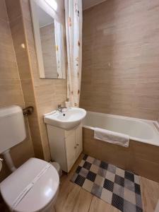 a bathroom with a toilet and a sink and a tub at Focus Home in Miercurea-Ciuc