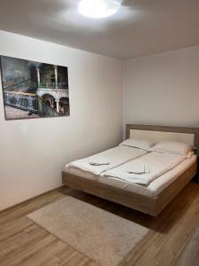 una camera da letto con un letto e un quadro sul muro di Focus Home a Miercurea-Ciuc