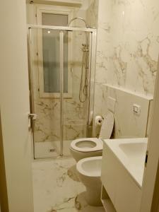 een witte badkamer met toilet en douche bij Il sorriso romagnolo in Misano Adriatico +7 foto's