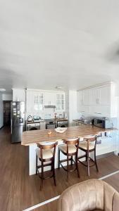 eine Küche mit einem großen Holztisch und Stühlen in der Unterkunft Luxury Beach Front Apartment in Strand