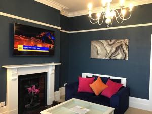 a living room with a couch and a tv at 2 Bed Apt Central Truro Ground-Floor Apartment in Kenwyn