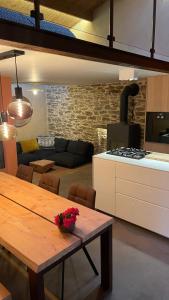 La Saulzaie في ليل ديو: مطبخ وغرفة معيشة مع طاولة وموقد