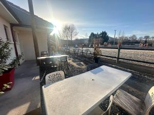 a white table and chairs next to a fence at Unique, Chambre 2,centre équestre & snacks in Vic-le-Comte