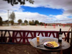 a table with a plate of food and a bottle of wine at Unique, Chambre 2,centre équestre & snacks in Vic-le-Comte