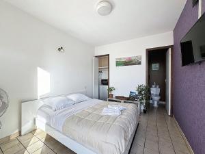 a bedroom with a large bed and a bathroom at Unique, Chambre 2,centre équestre & snacks in Vic-le-Comte
