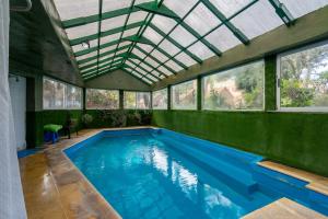 an indoor swimming pool with a glass ceiling at Pinamar De La Lisa in Pinamar