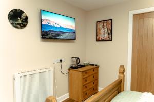 a bedroom with a dresser and a clock on the wall at The Sycamore Inn in Birch Vale +59 photos