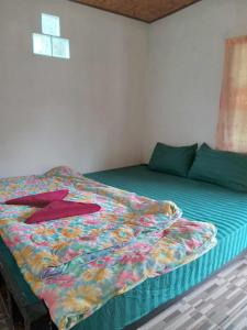 a bed with a colorful comforter in a room at โบว์ ปางอุ๋ง in Ban Huai Makhuea Som
