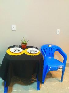 una sedia blu seduta accanto a un tavolo con due bicchieri di Flat Oásis- Super aconchegante a Tangará da Serra Altre 13 foto