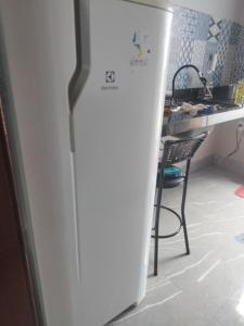 un frigorifero bianco in una cucina accanto a un tavolo di Flat Oásis- Super aconchegante a Tangará da Serra