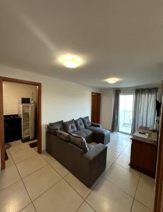 un soggiorno con divano e cucina di Le Bon vivant Arraial do cabo 405 bl a ad Arraial do Cabo