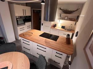 een keuken met witte kasten en een houten aanrechtblad bij See-Maisonette mit Wellness-Sauna in Öhningen