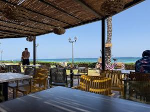 a restaurant with tables and chairs and a view of the beach at Playa Azul in Restinga Smir