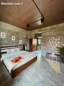 Un dormitorio con una cama grande en una habitación. en หมี่ก่าโฮมสเตย์, en Ban Pha Mi