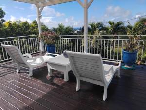 two white chairs and a table on a deck at Kote mer Villa Bayside in Sainte-Anne