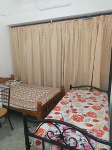 una camera con due letti e una tenda di Giri Comforts a Mangalore